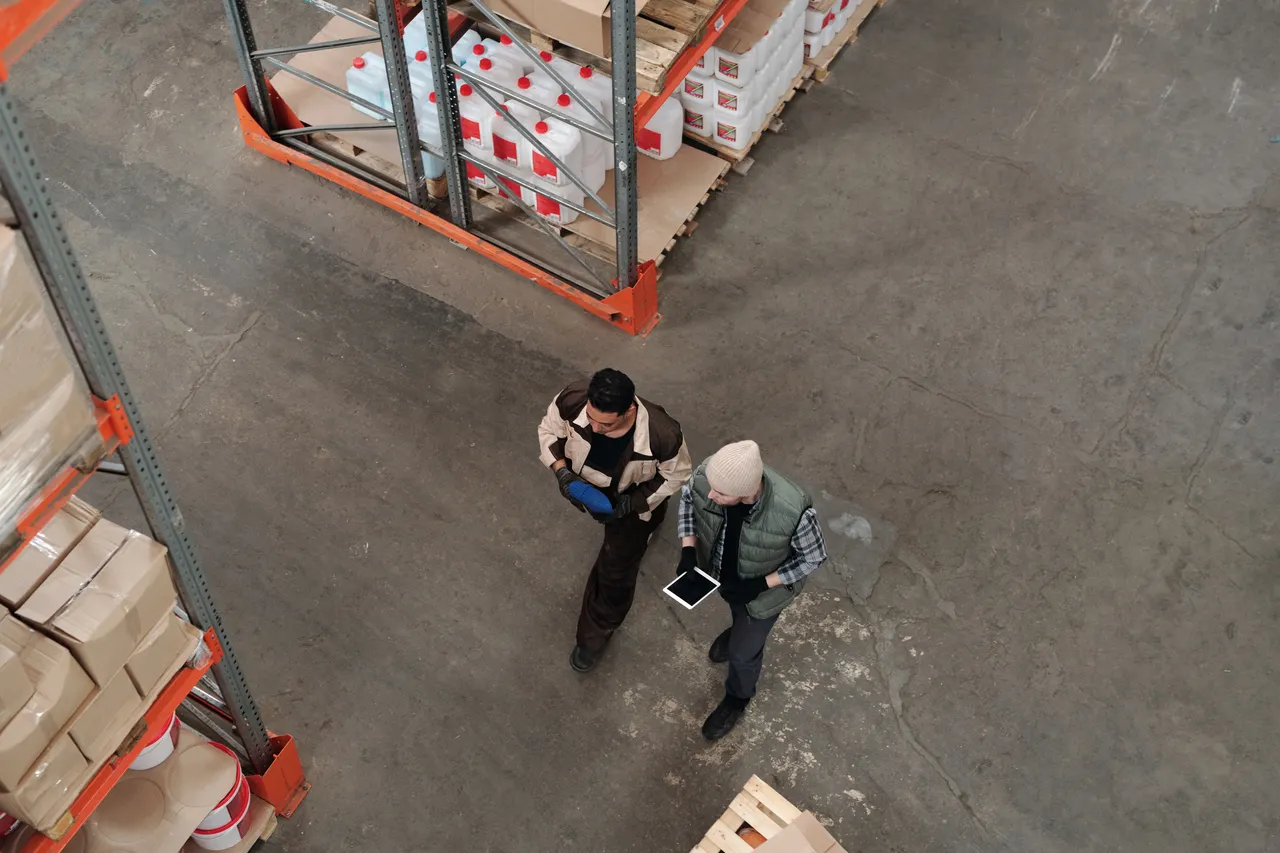 Deux professionnels consultent une tablette dans un entrepôt